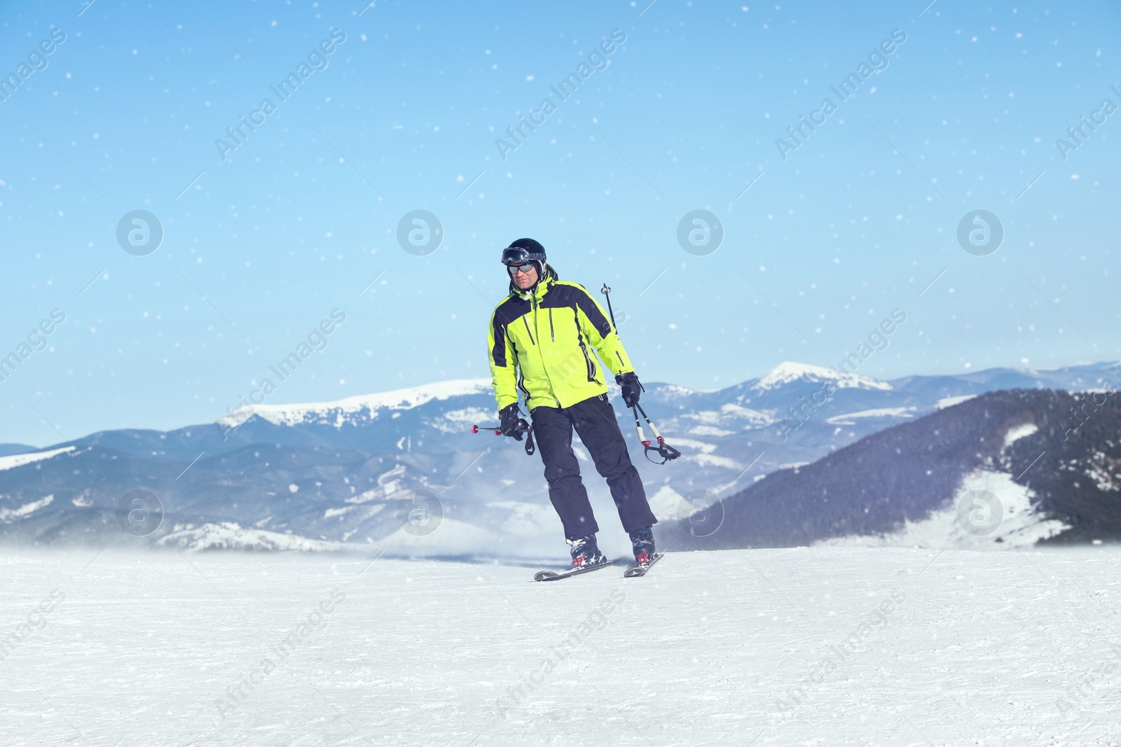 Photo of Male skier on snowy slope in mountains. Winter vacation