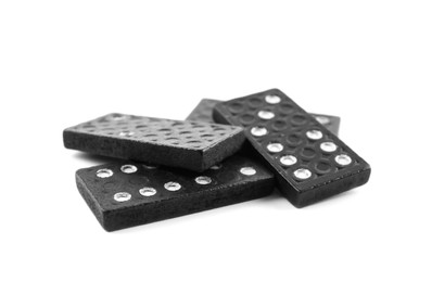 Photo of Pile of black domino tiles on white background