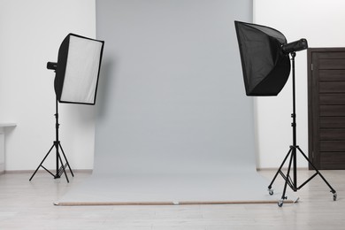 Photo of Modern light grey photo background and softboxes in studio
