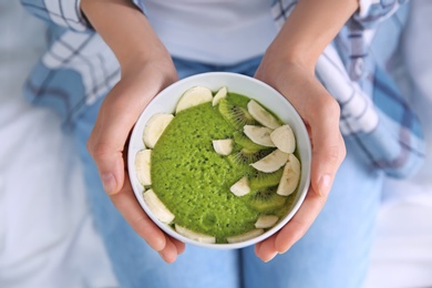 Photo of Young woman with bowl of healthy smoothie, closeup