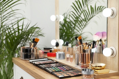 Photo of Set of luxury makeup products and accessories on dressing table with mirror. Space for text