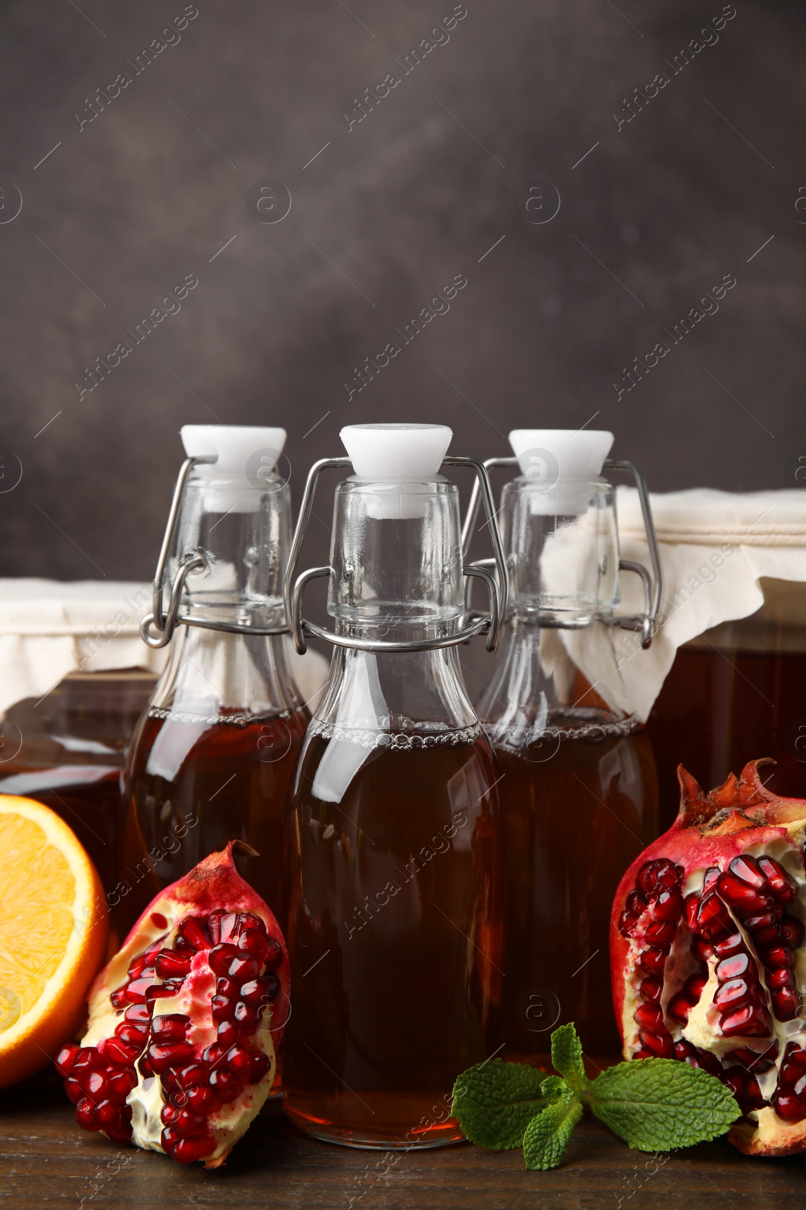 Photo of Tasty kombucha, mint and fresh fruits on wooden table