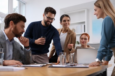 Photo of Team of employees working together in office