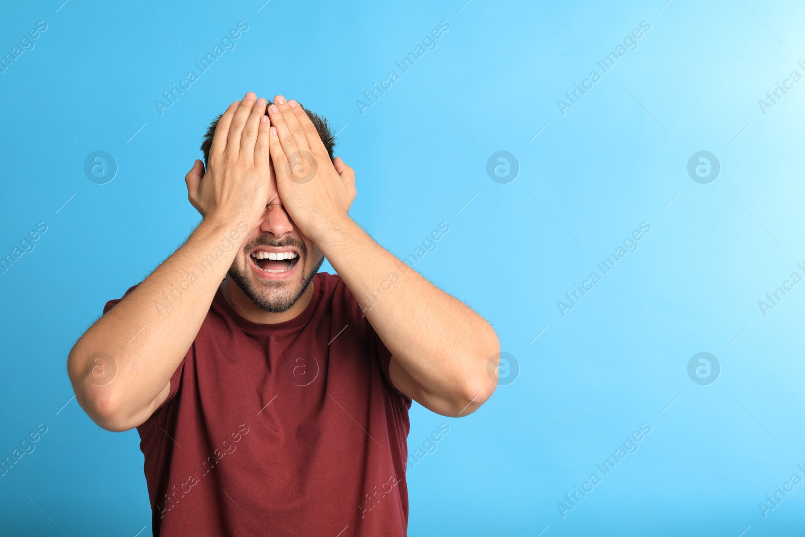 Photo of Young man being blinded on blue background, space for text