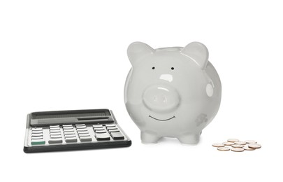 Photo of Piggy bank, coins and calculator on white background
