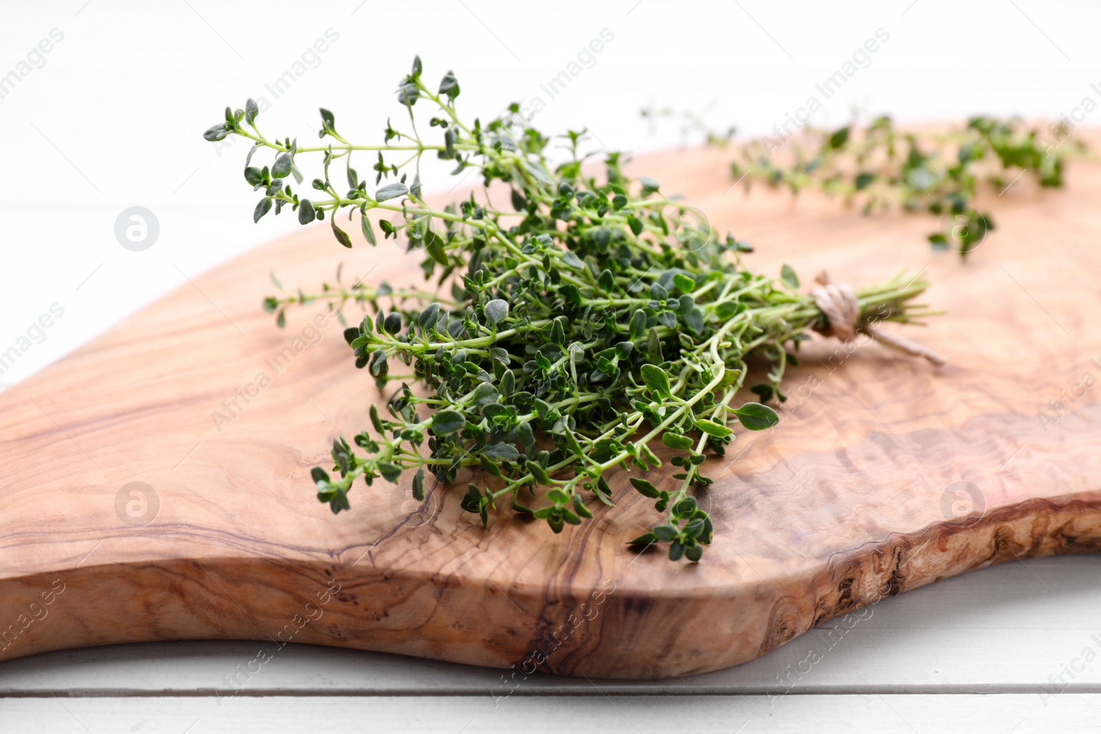 Photo of Bunch of aromatic thyme on white wooden table, closeup. Fresh herb