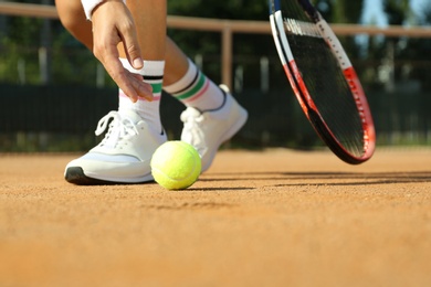 Photo of Sportswoman playing tennis at court on sunny day, closeup