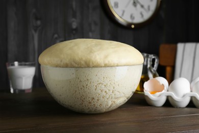 Fresh yeast dough and ingredients on wooden table