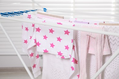 Photo of Different apparel drying on clothes airer indoors, closeup