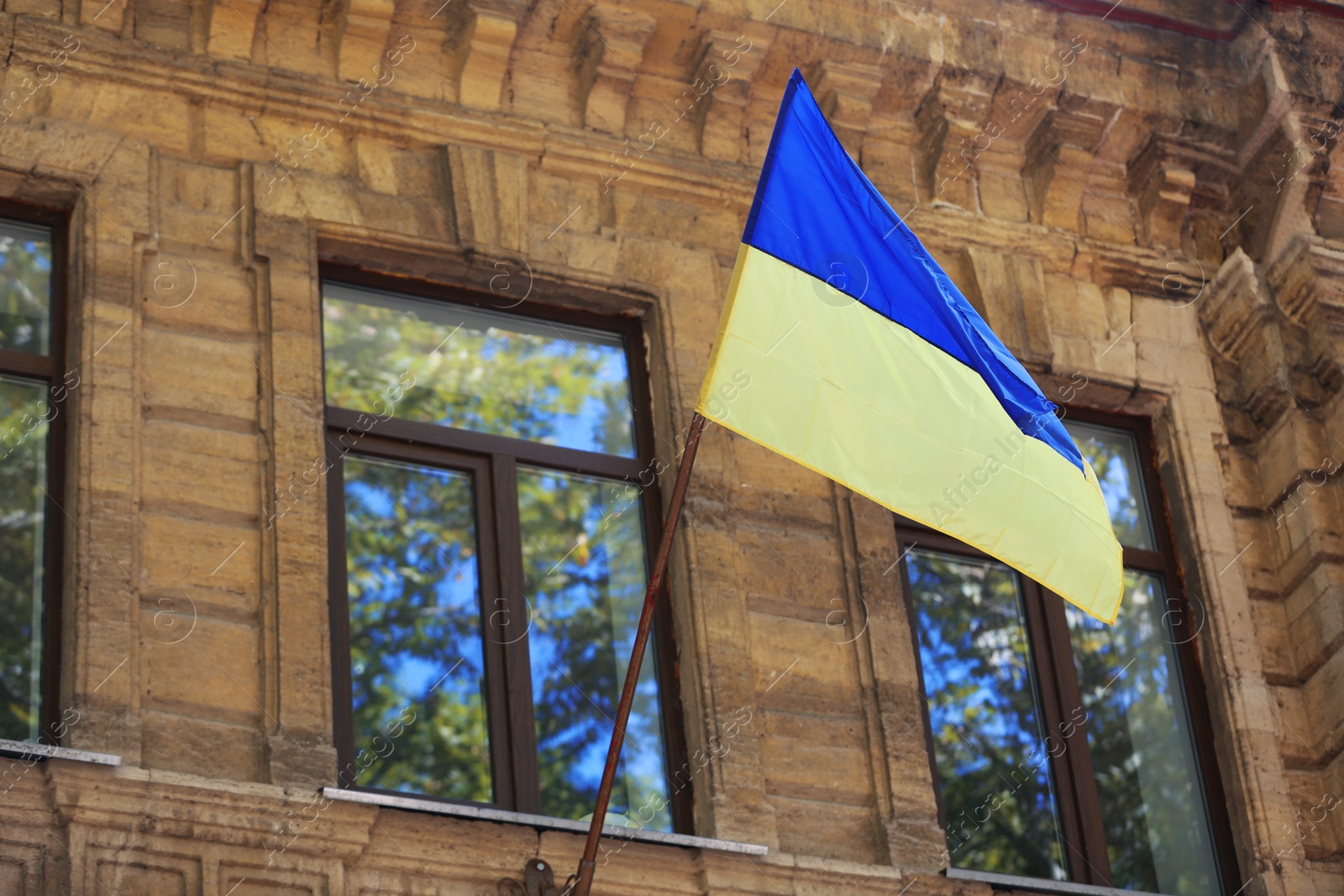 Photo of National flag of Ukraine on old building wall outdoors