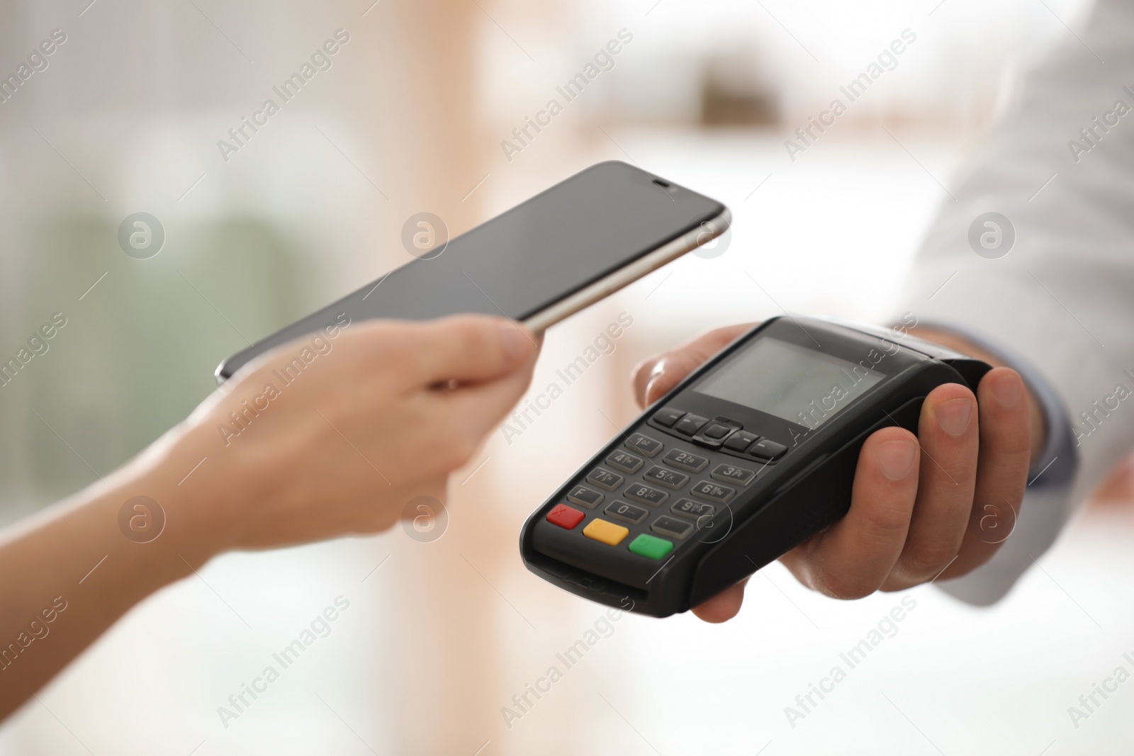 Photo of Customer using terminal for contactless payment with smartphone in pharmacy, closeup