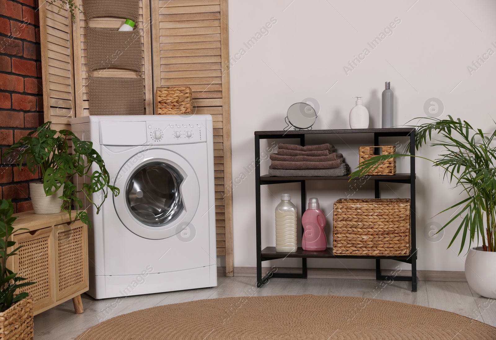 Photo of Stylish laundry room with washing machine. Interior design