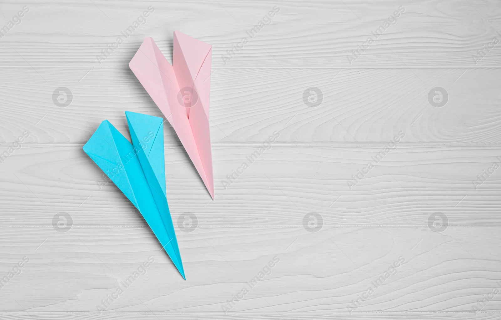 Photo of Handmade paper planes on white wooden table, flat lay. Space for text