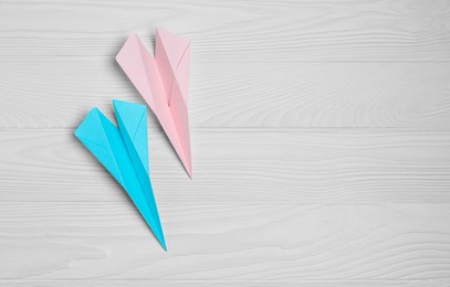 Photo of Handmade paper planes on white wooden table, flat lay. Space for text