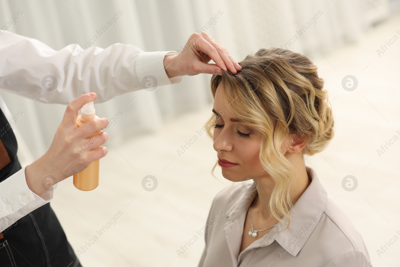 Photo of Hair styling. Professional hairdresser working with client indoors, closeup