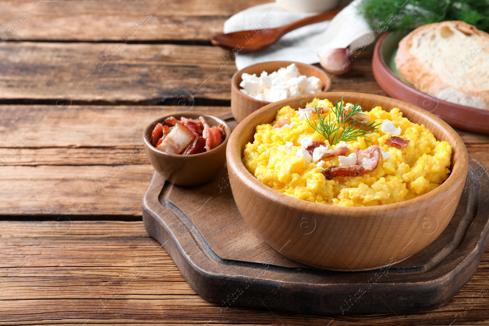 Photo of Tasty banosh served with brynza and pork cracklings on wooden table, space for text. Traditional Ukrainian dish