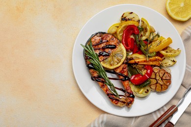 Photo of Tasty salmon steak with sauce, lemon and vegetables on light table, flat lay. Space for text