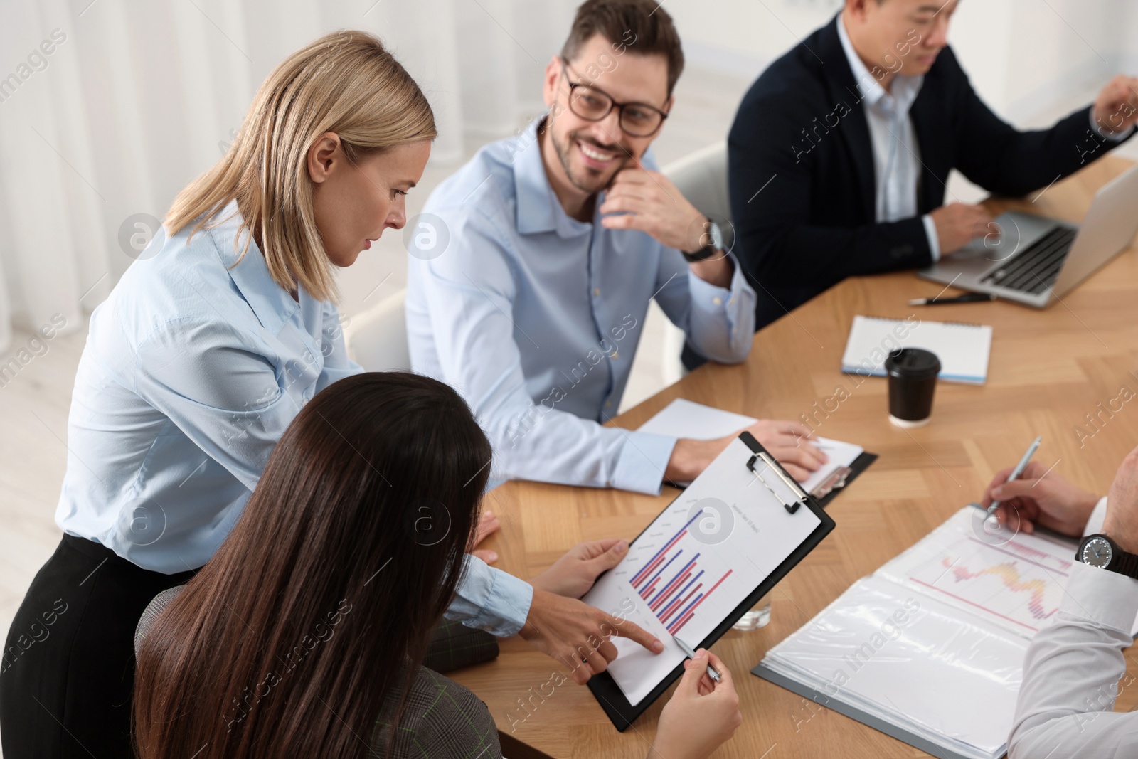 Photo of Businesswoman having meeting with her employees in office