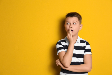 Photo of Portrait of emotional preteen boy on yellow background. Space for text