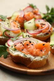 Tasty canapes with salmon served on light grey table, closeup