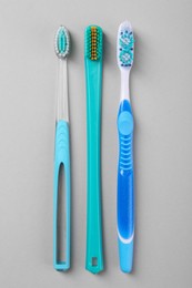 Many different toothbrushes on light background, flat lay