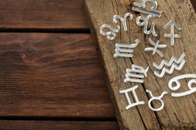 Photo of Zodiac signs on wooden table, above view. Space for text