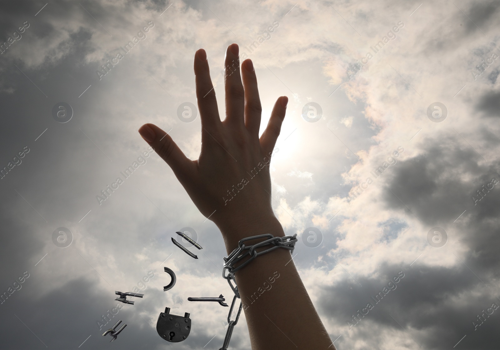 Image of Freedom. Woman with broken chain against cloudy sky, closeup