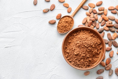 Photo of Flat lay composition with cocoa powder and beans on light background