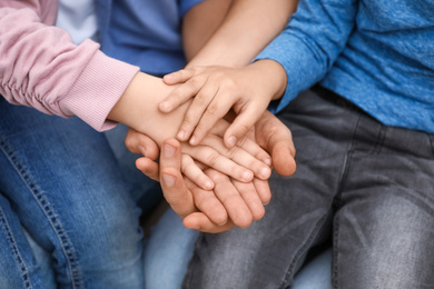 Photo of Closeup view of happy family holding hands