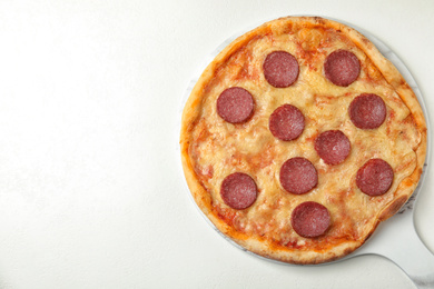 Photo of Tasty pepperoni pizza on white table, top view. Space for text