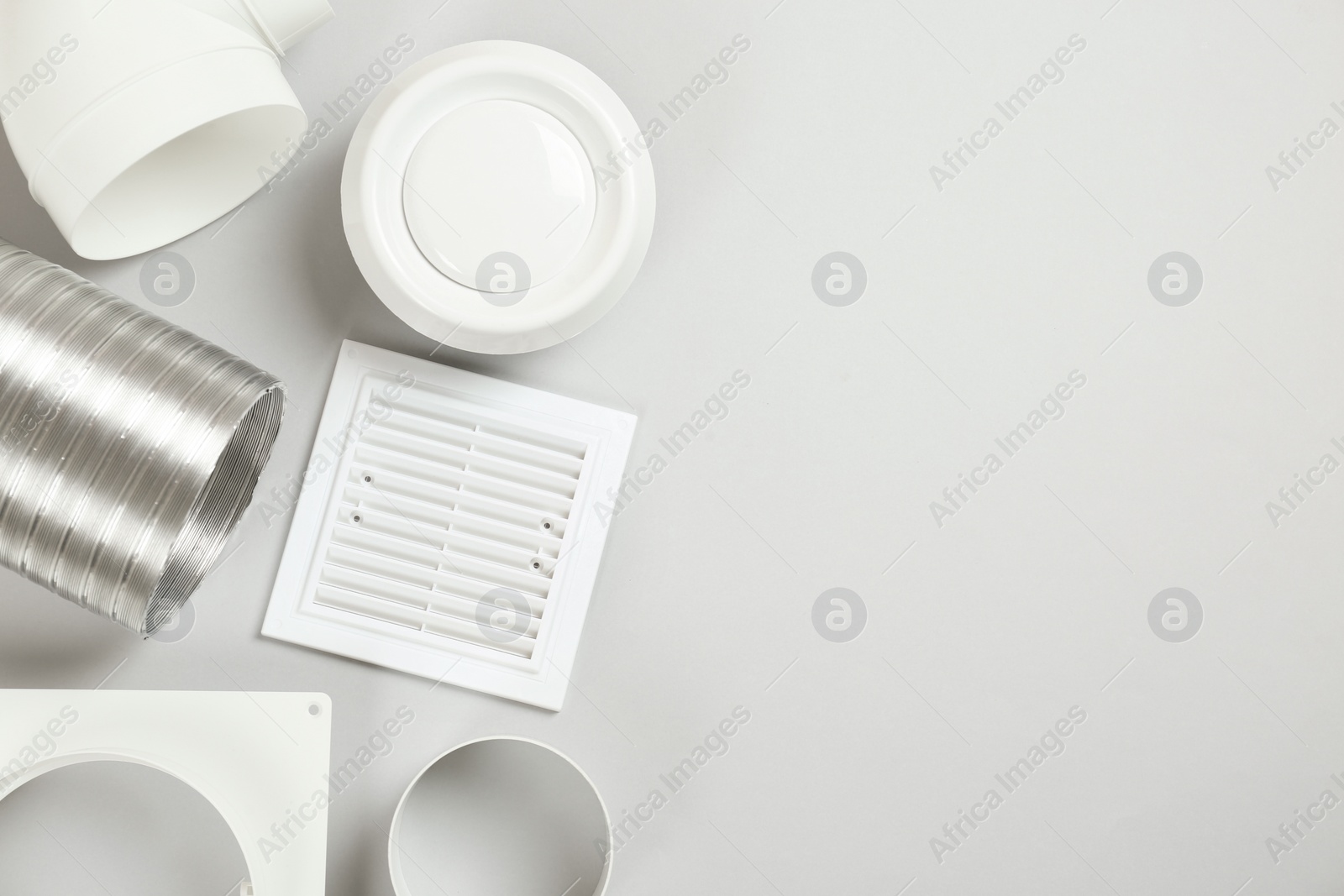 Photo of Parts of home ventilation system on light grey background, flat lay. Space for text