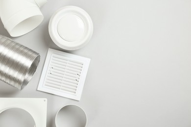 Photo of Parts of home ventilation system on light grey background, flat lay. Space for text