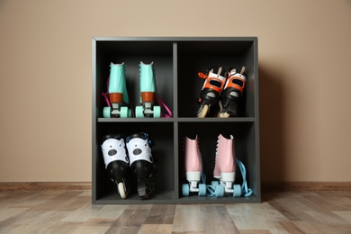 Pairs of roller skates on shelves near light wall