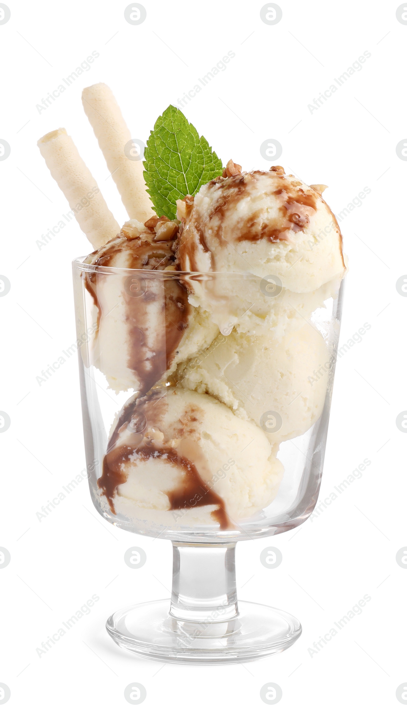 Photo of Glass dessert bowl of tasty vanilla ice cream with caramel sauce, nuts and wafer rolls isolated on white