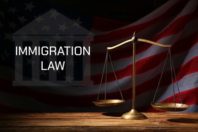 Image of Immigration law. Scales of justice on wooden table against American flag in darkness