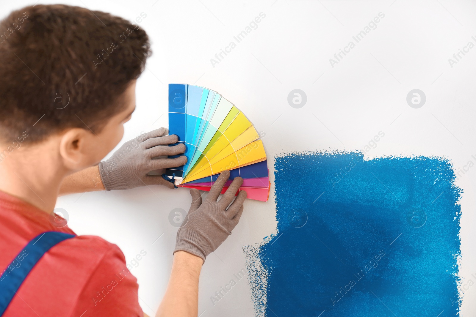 Photo of Male decorator holding color palette samples, closeup