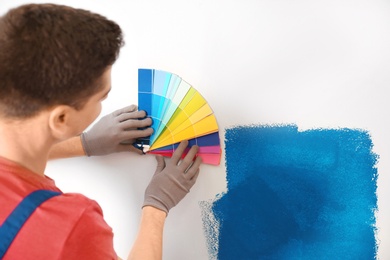 Photo of Male decorator holding color palette samples, closeup