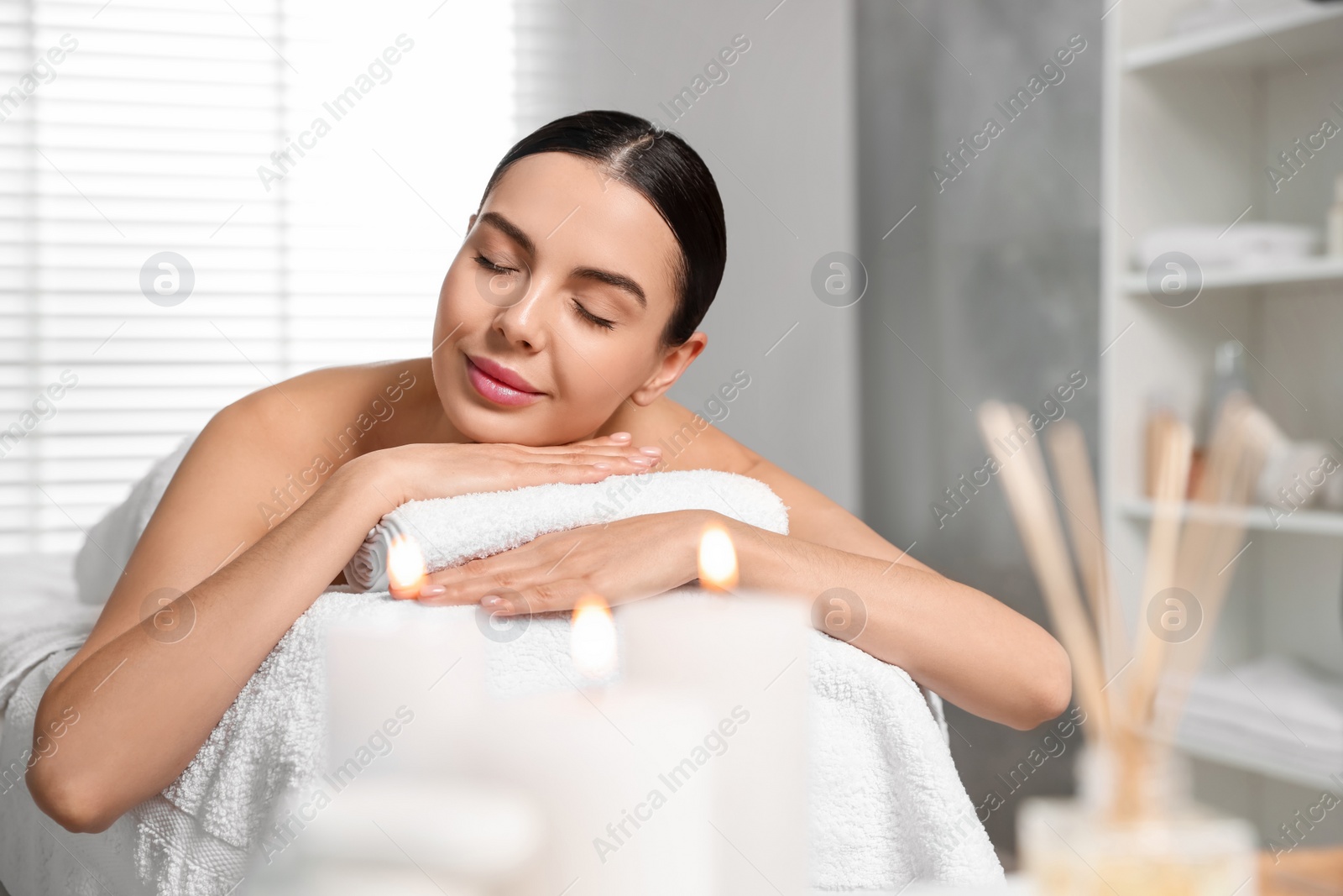 Photo of Beautiful woman relaxing on massage table in spa salon