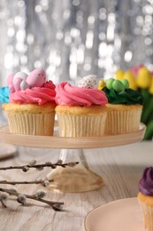 Photo of Tasty cupcakes with Easter decor on wooden table, closeup