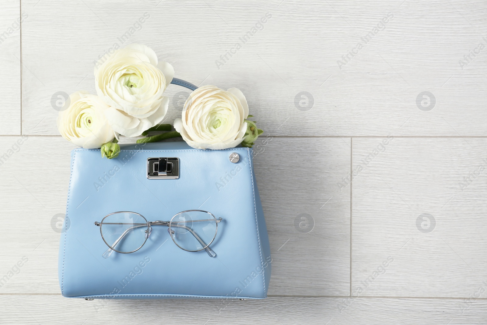 Photo of Flat lay composition with stylish bag and spring flowers on wooden background. Space for text