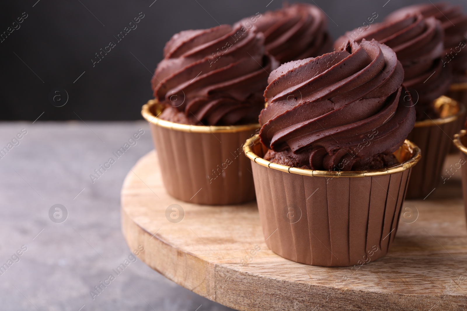 Photo of Delicious chocolate cupcakes on grey table, closeup