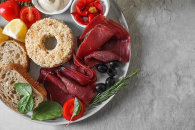 Photo of Delicious bresaola and other ingredients for sandwich on light table, top view. Space for text