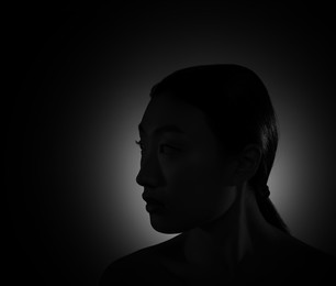 Silhouette of woman in darkness. Portrait on black background