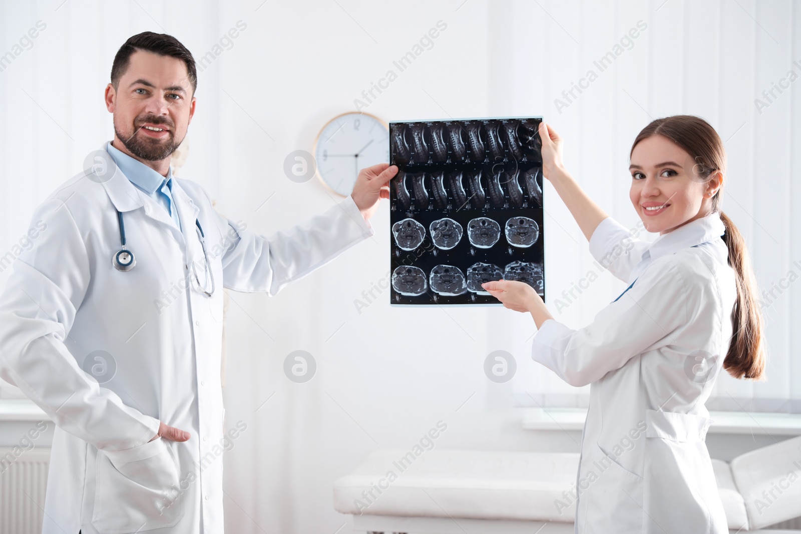 Photo of Professional orthopedist and his colleague examining X-ray picture in office