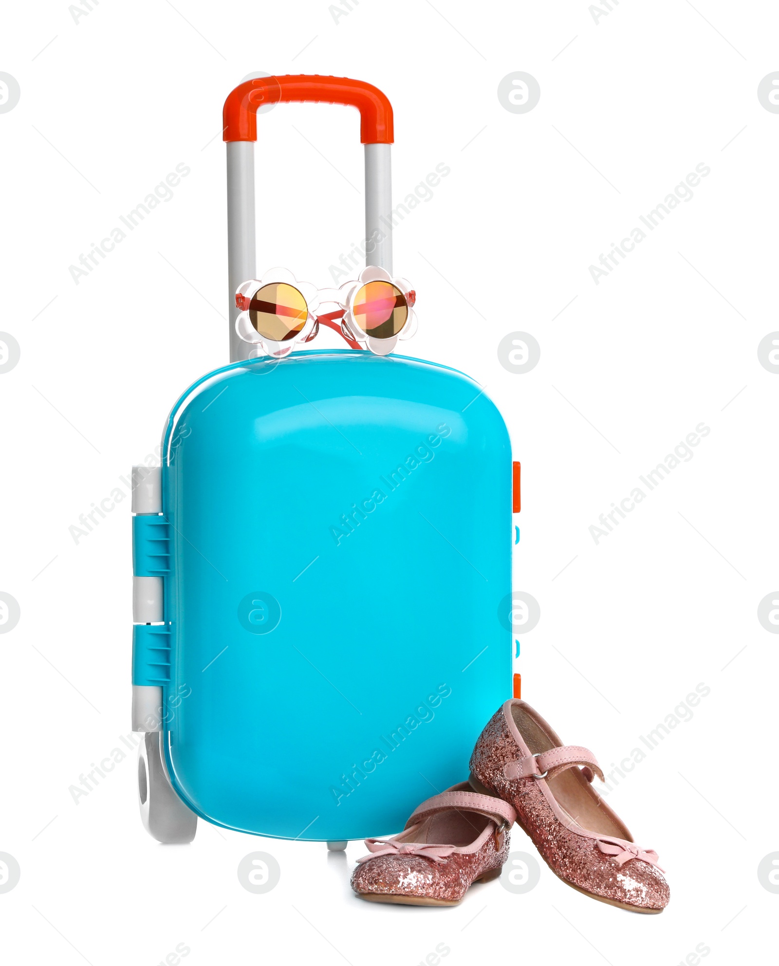 Photo of Stylish little blue suitcase with sunglasses and shoes on white background