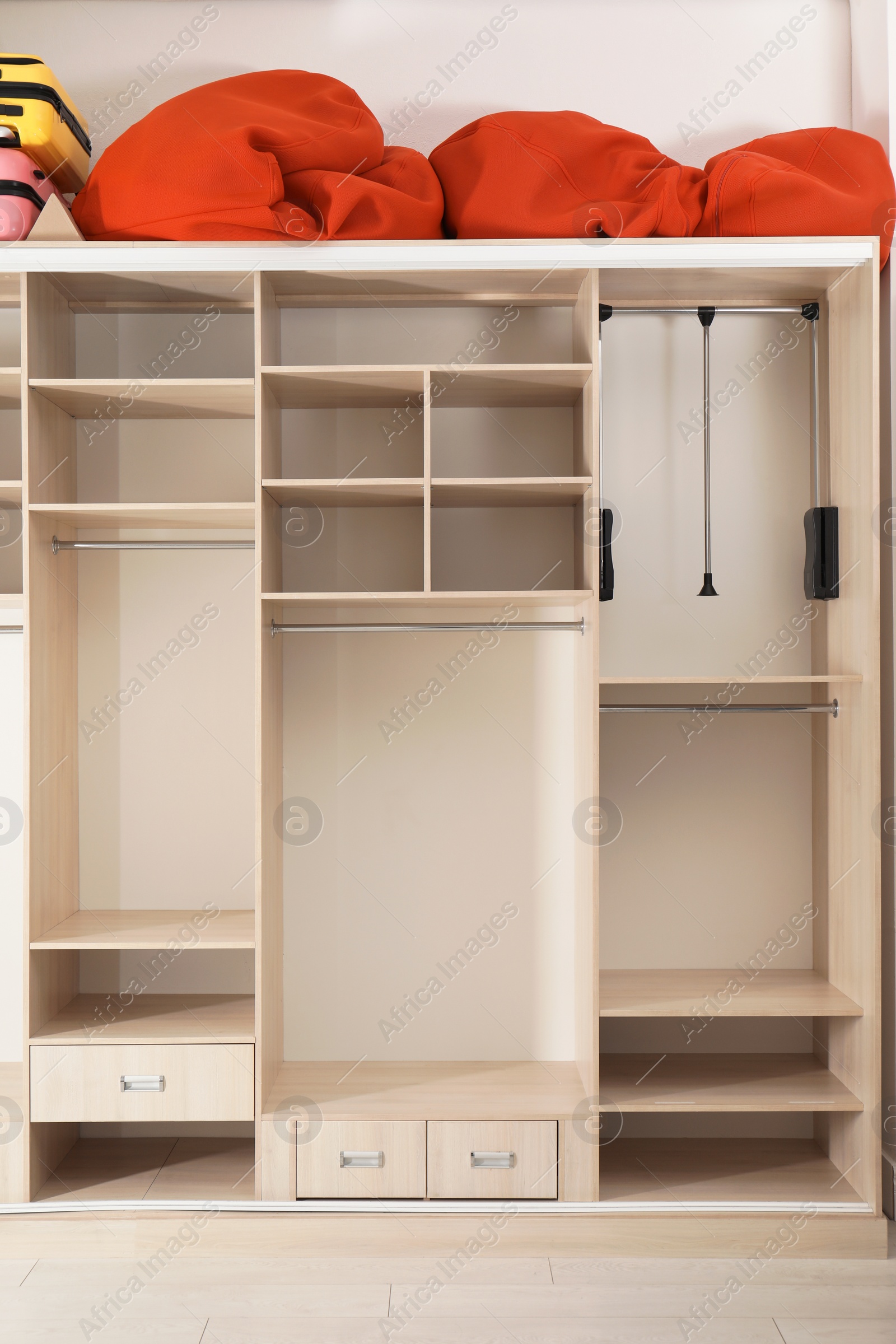 Photo of Empty wardrobe with bags and suitcases on top in dressing room