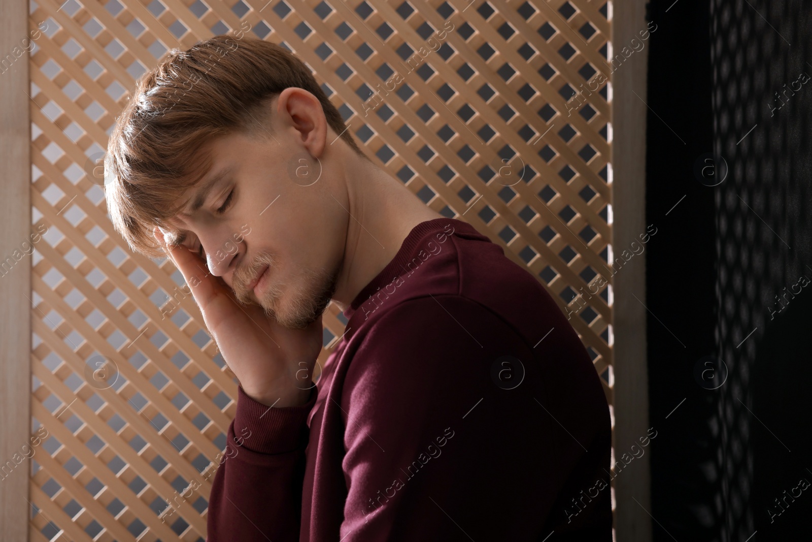 Photo of Upset young man during confession in booth