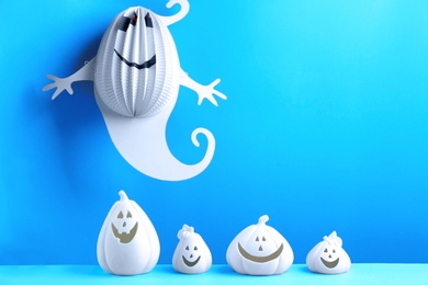 Composition with pumpkin shaped candle holders on blue background. Halloween decoration