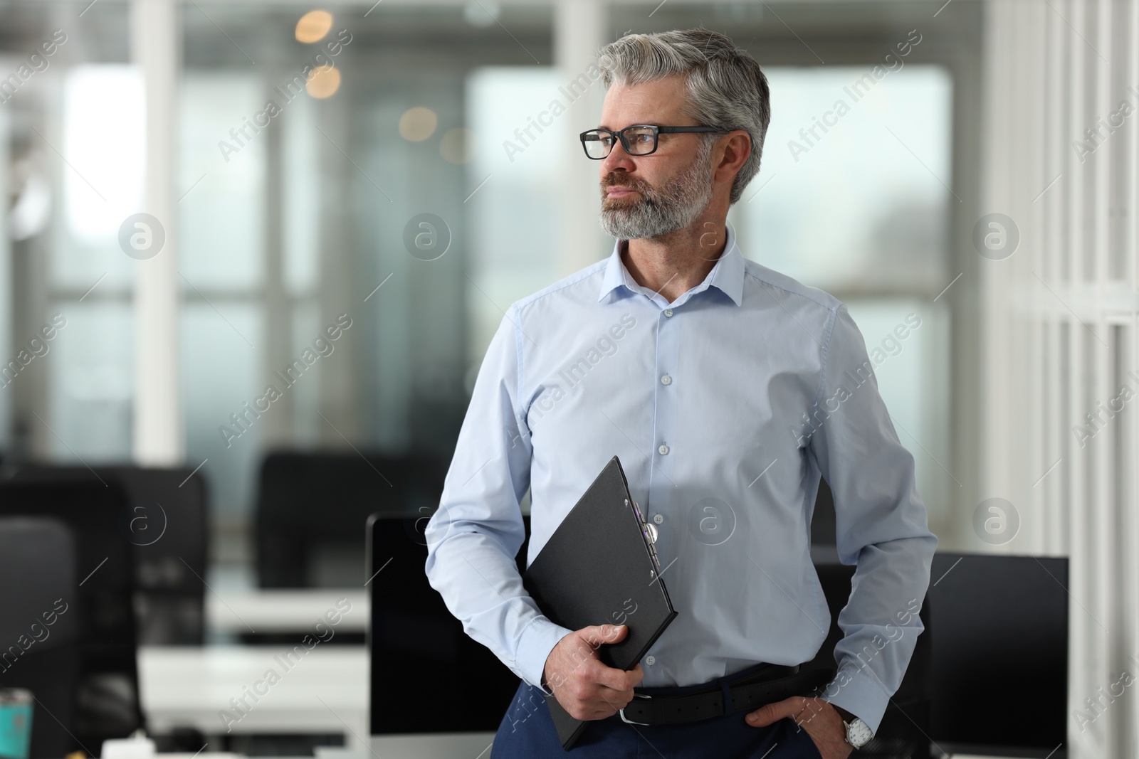 Photo of Handsome man with clipboard in office, space for text. Lawyer, businessman, accountant or manager