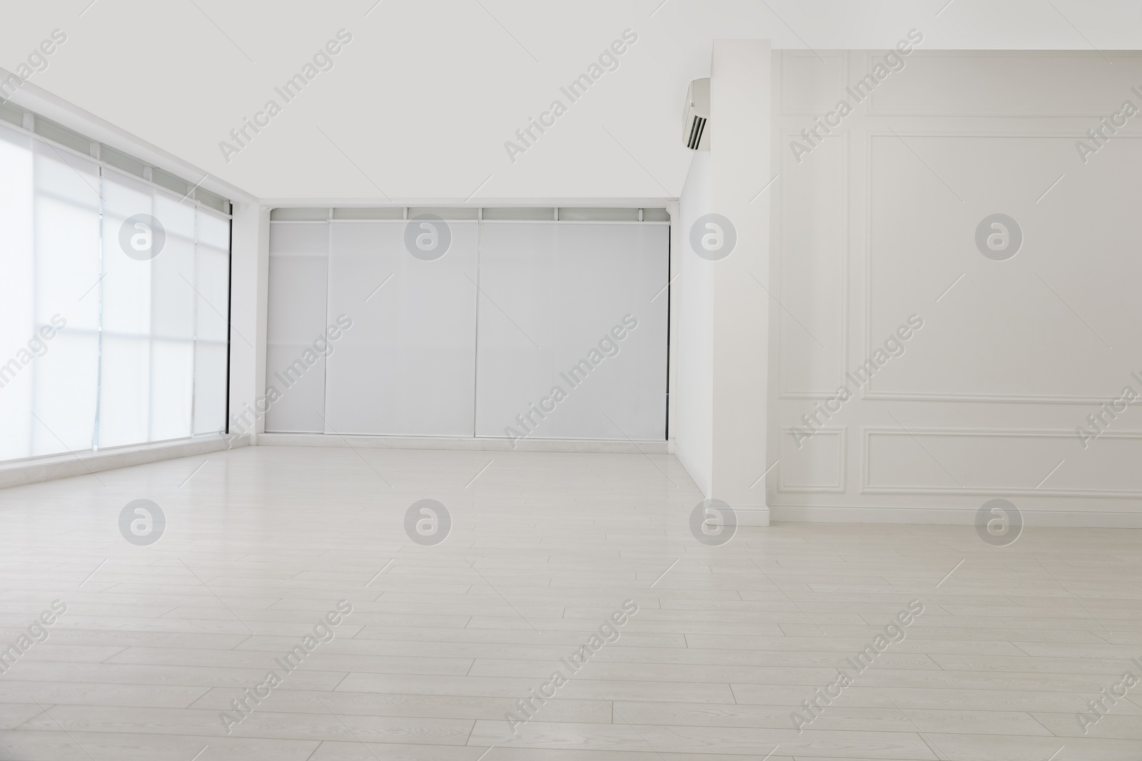 Photo of Empty room with white walls and laminated flooring